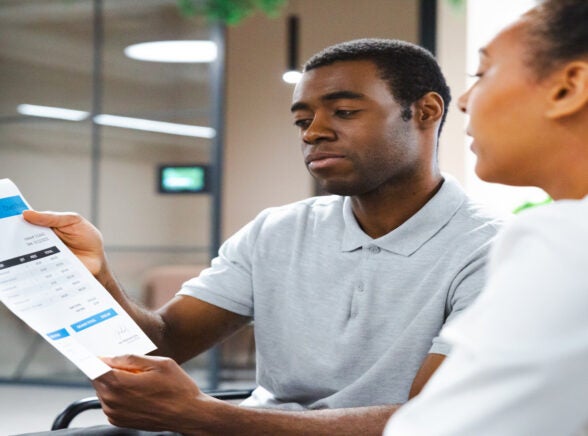 Two people examining an invoice. Source: Tech.co