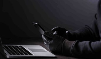 Hacker in gloves with phone