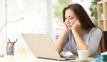Remote worker looking bored staring at laptop screen