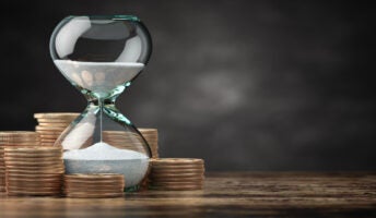 hourglass surrounded by money