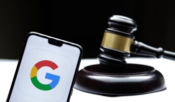 Google logo on phone with gavel behind.