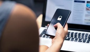 Locked phone screen in front of laptop