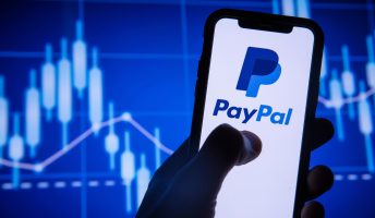 PayPal on phone screen in front of stocks