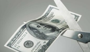 Scissors cutting money