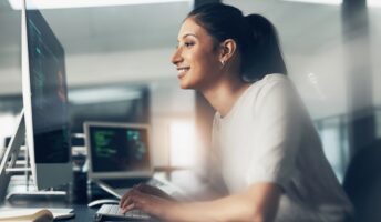 Woman coder smiling at laptop