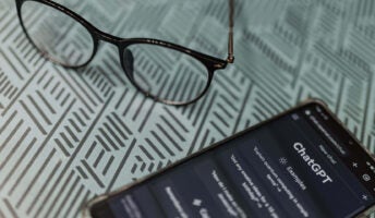 ChatGPT on a phone, near glasses.
