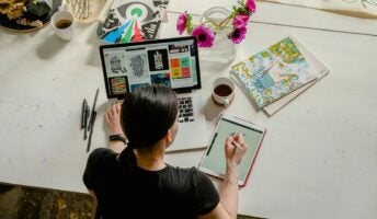 A woman does creative design work on a Mac.