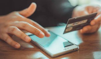 person using phone with credit card