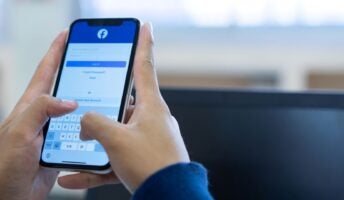 Man trying to log in to Facebook app or website on mobile phone
