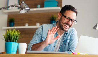 man waving on video call