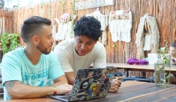 two remote workers in Mexico looking at laptop