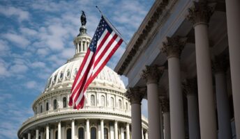 A photo of the US Capitol in front of the American flag.