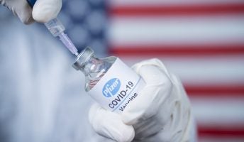 covid vaccine in front of usa flag